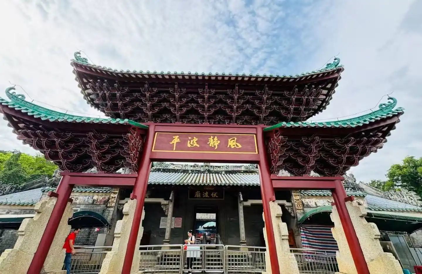 Ornate Chinese temple gate with sweeping green-tiled roofs and a gold plaque; visitors pass through the entrance.Fubo Hill Temple,Guilin,Guangxi ,Chinatravel