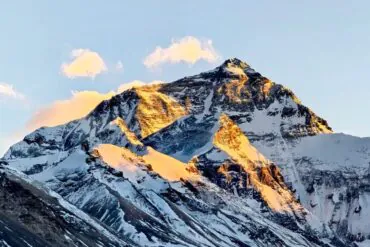 Snow-capped mountain peak bathed in warm sunset light against a clear blue sky.Mount Everest Base Camp,Lhasa,Tibet,Chinatravel