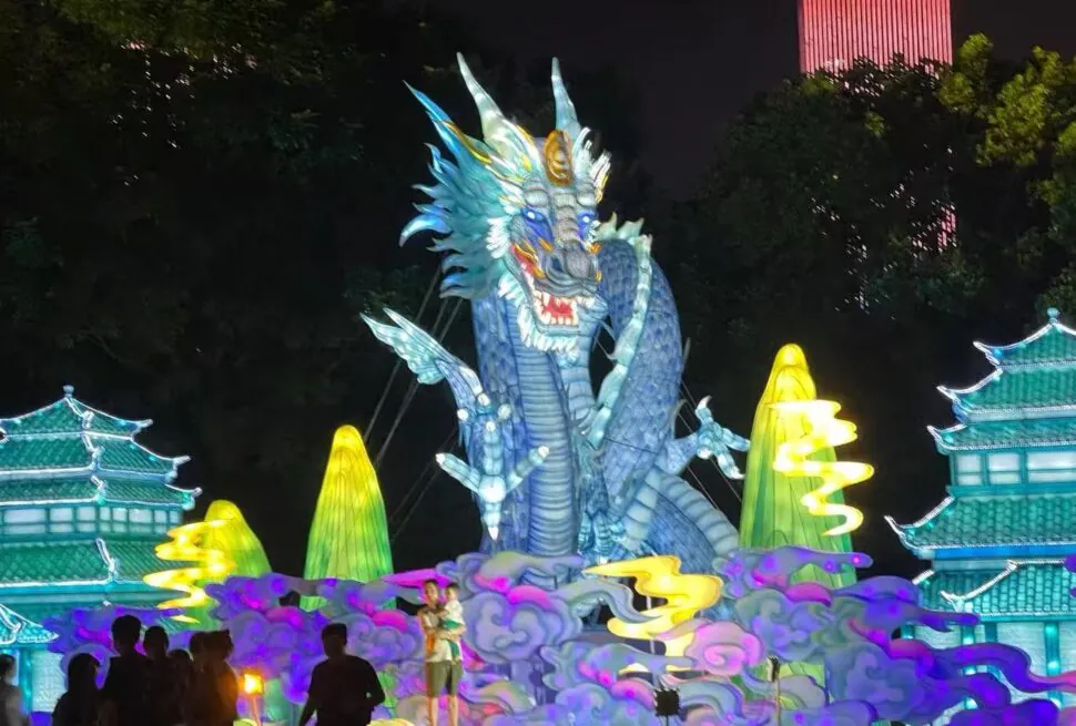 Illuminated blue dragon sculpture at a night festival, surrounded by glowing clouds and pagoda buildings.Orange Isle (Juzizhou) Pavilion,Changsha,Hunan ,Chinatravel