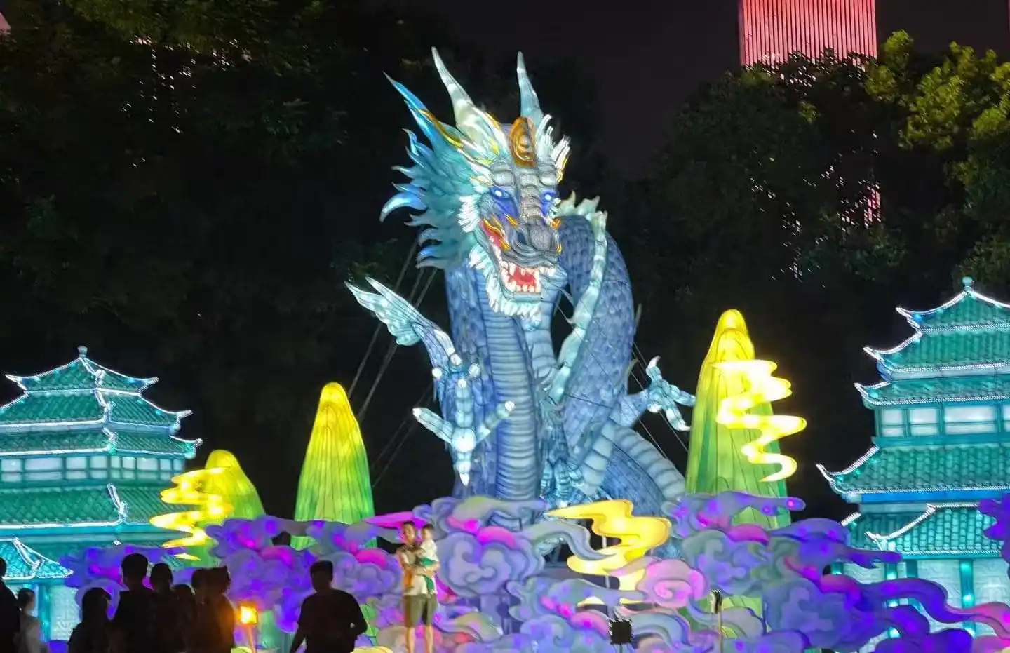 Illuminated blue dragon sculpture at a night festival, surrounded by glowing clouds and pagoda buildings.Orange Isle (Juzizhou) Pavilion,Changsha,Hunan ,Chinatravel