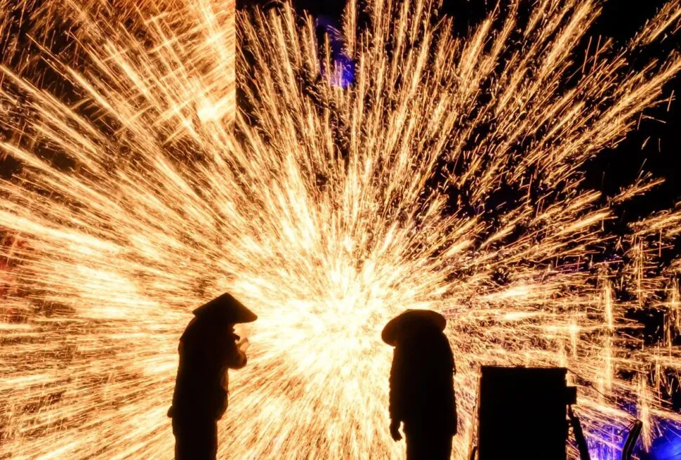 Two silhouettes watch a bright shower of golden sparks against a dark night.Datiehua,𝐂𝐡𝐢𝐧𝐞𝐬𝐞 𝐍𝐞𝐰 𝐘𝐞𝐚𝐫,Henan,Chinatravel