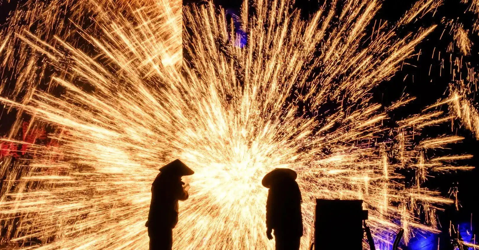 Two silhouettes watch a bright shower of golden sparks against a dark night.Datiehua,𝐂𝐡𝐢𝐧𝐞𝐬𝐞 𝐍𝐞𝐰 𝐘𝐞𝐚𝐫,Henan,Chinatravel