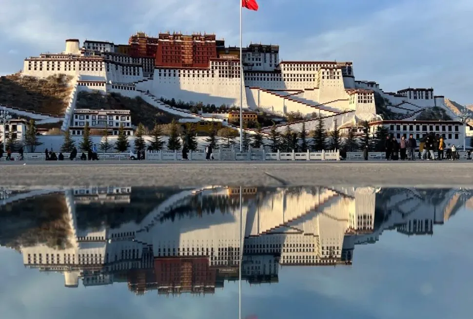 Potala Palace perched on a hill with a red flag, reflected in a calm water surface below,Potala Palace,Lhasa,Tibet,Chinatravel