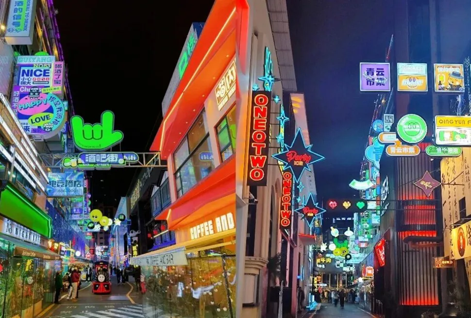Neon-lit street in an East Asian shopping district at night with colorful signs and storefronts, pedestrians walking.Qingyun Market,Guiyang,Guizhou