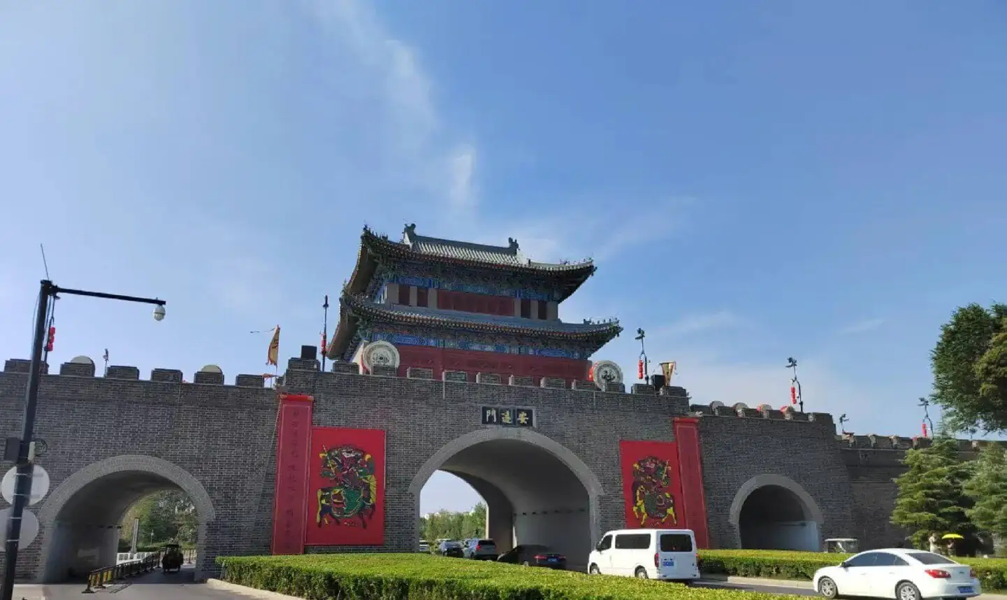 Kaifeng Ancient City Wall,Kaifeng,Henan,Chinatravel Traditional Chinese city gate with a multi-tier pagoda on top, gray brick walls, red banners, and arched entryways.