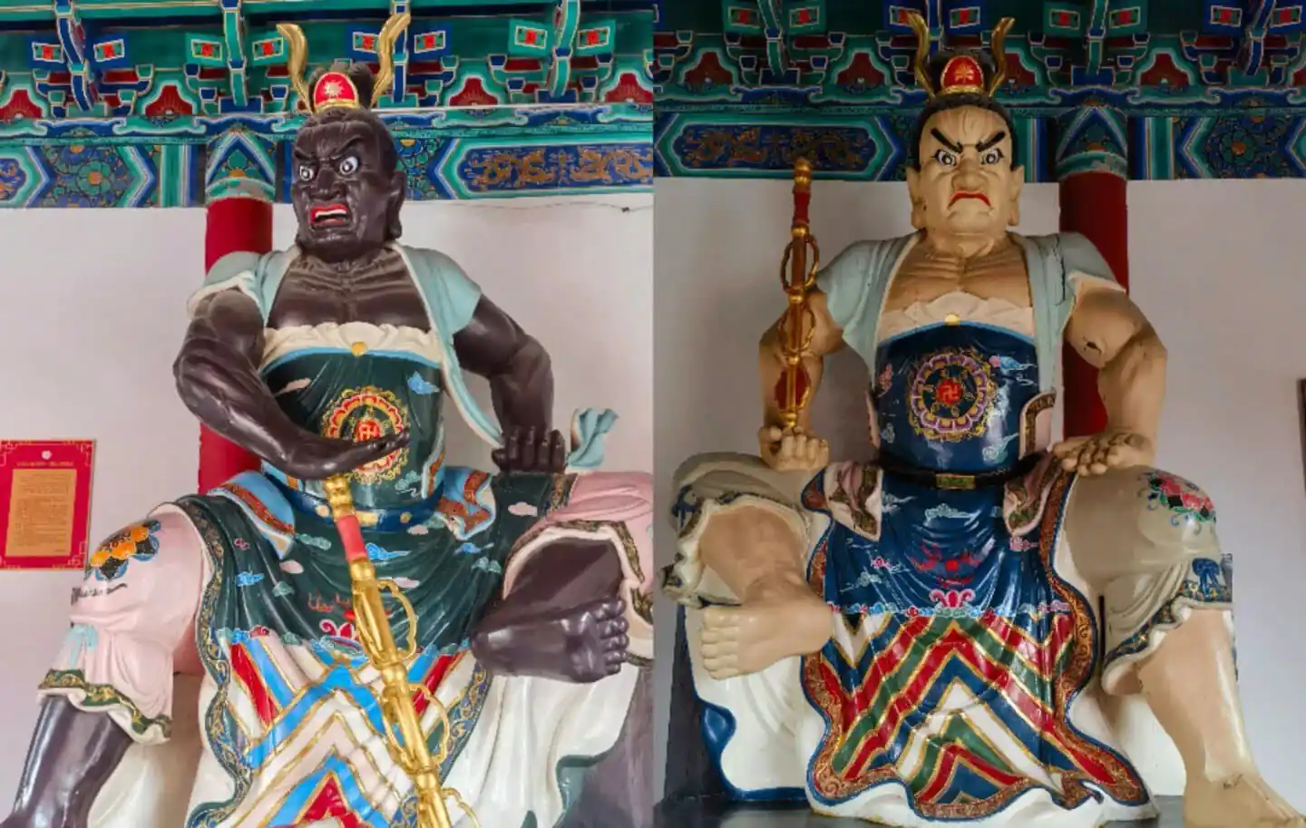 Daxiangguo Temple,Kaifeng,Henan,Chinatravel Two enormous guardian warrior statues in ornate robes and headdresses, seated indoors with a decorative ceiling above.