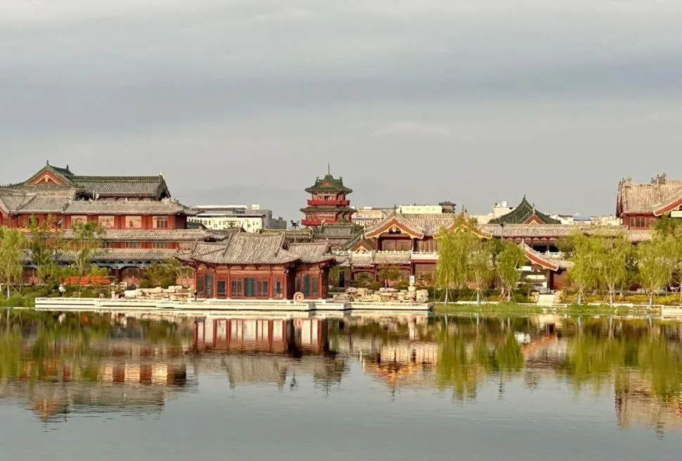 Baogong Lake & Park,Kaifeng,Henan,Chinatravel Traditional Chinese temple complex along a calm lake with reflections in the water and trees lining the shore.