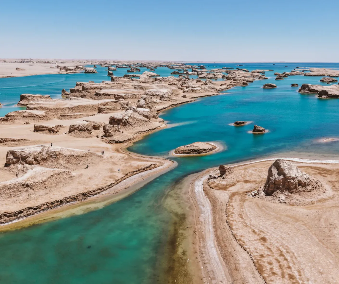 Desert coastline with turquoise tidal pools and layered rock formations under a clear blue sky,Wusute Water Yadan,Haixi Prefecture,Qinghai ,Chinatravel