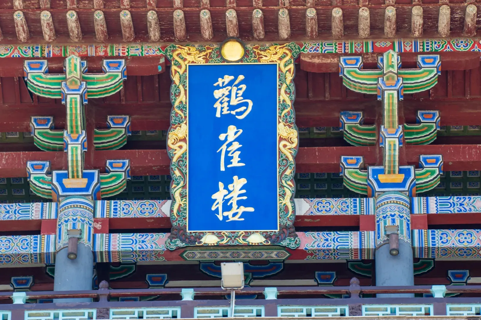 Close-up of a traditional Chinese building with colorful decorations and a blue sign with Chinese ch.