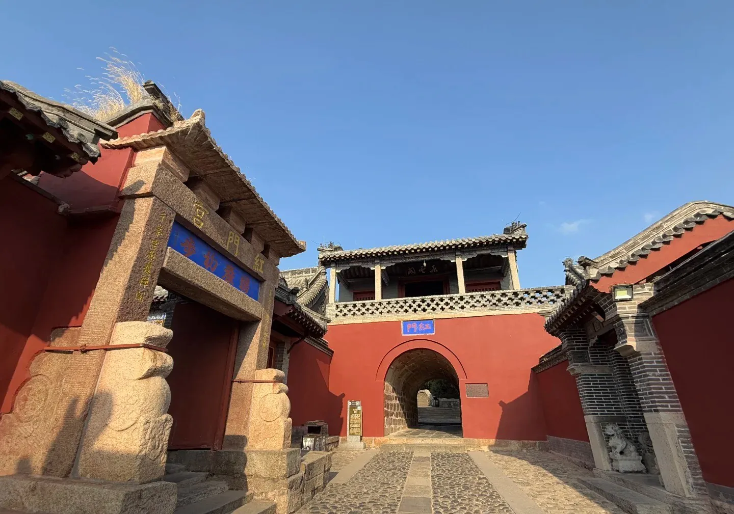 Red Gate Palace Scenic,Tai`an,Chinatour Traditional Chinese architecture with red walls and stone pathway in a historic site.