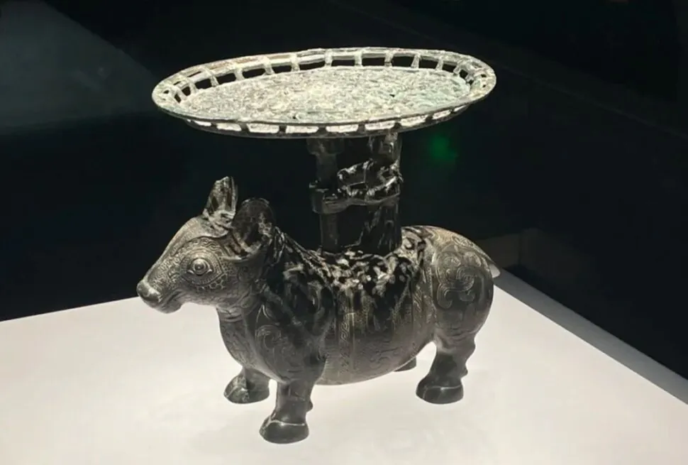 Decorative metal donkey statue with an ornate circular tray on its back, displayed on a white pedestal.Shanxi Museum,Taiyuan, Shanxi