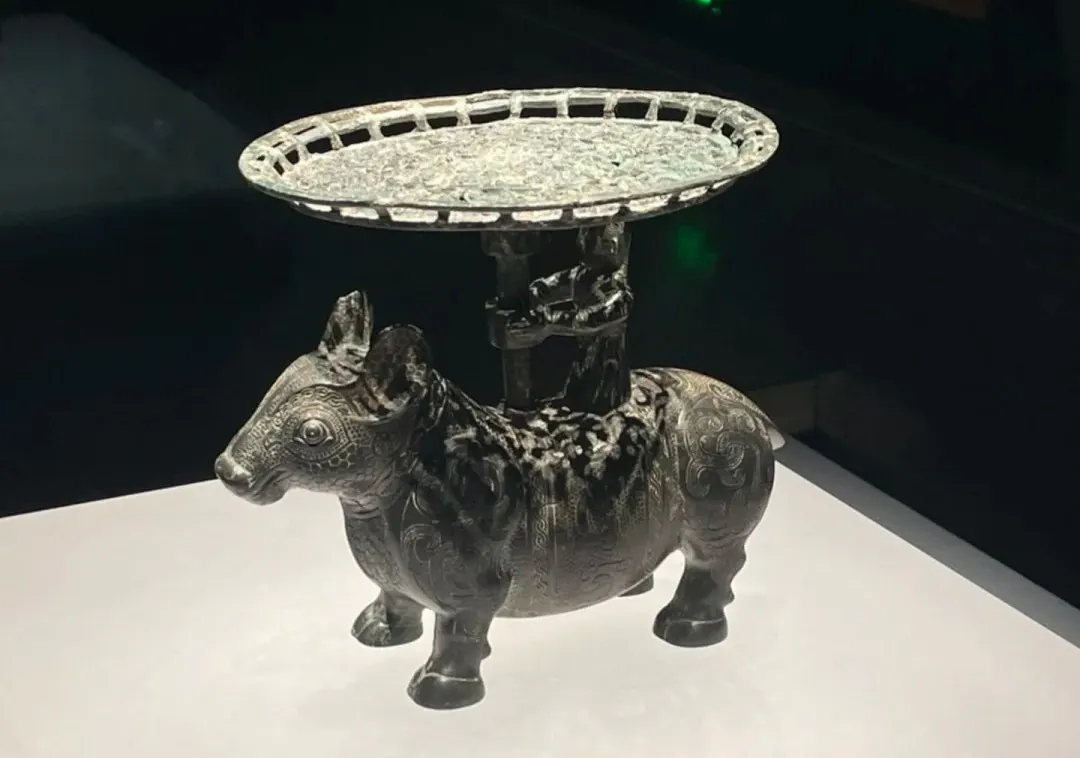Decorative metal donkey statue with an ornate circular tray on its back, displayed on a white pedestal.Shanxi Museum,Taiyuan, Shanxi