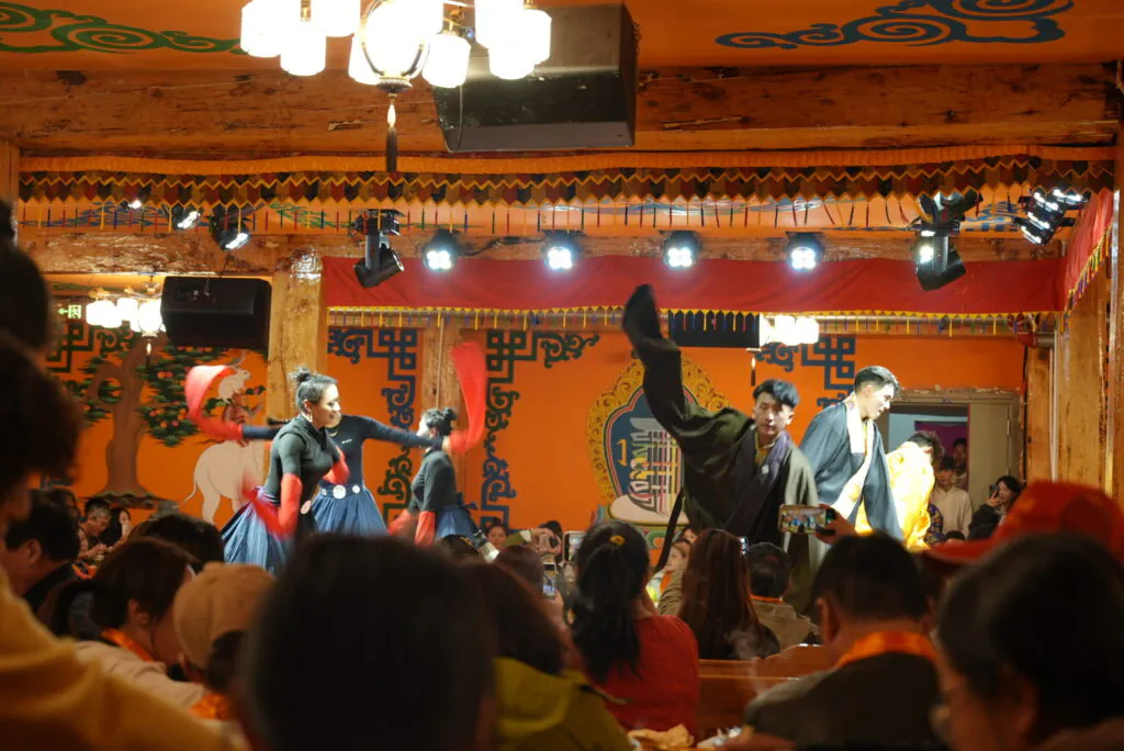 A vibrant cultural dance performance in a traditional Chinese setting with colorful decorations.