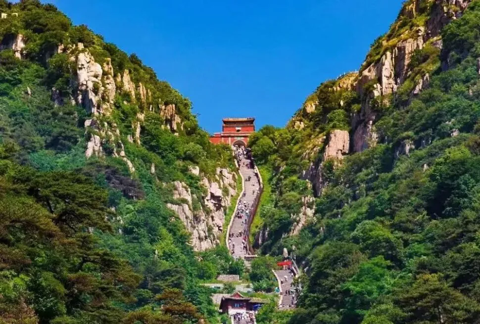 Jade Emperor Peak,Tai`an,Chinatour A scenic view of Mount Hua with a steep pathway and traditional Chinese temple at the top.