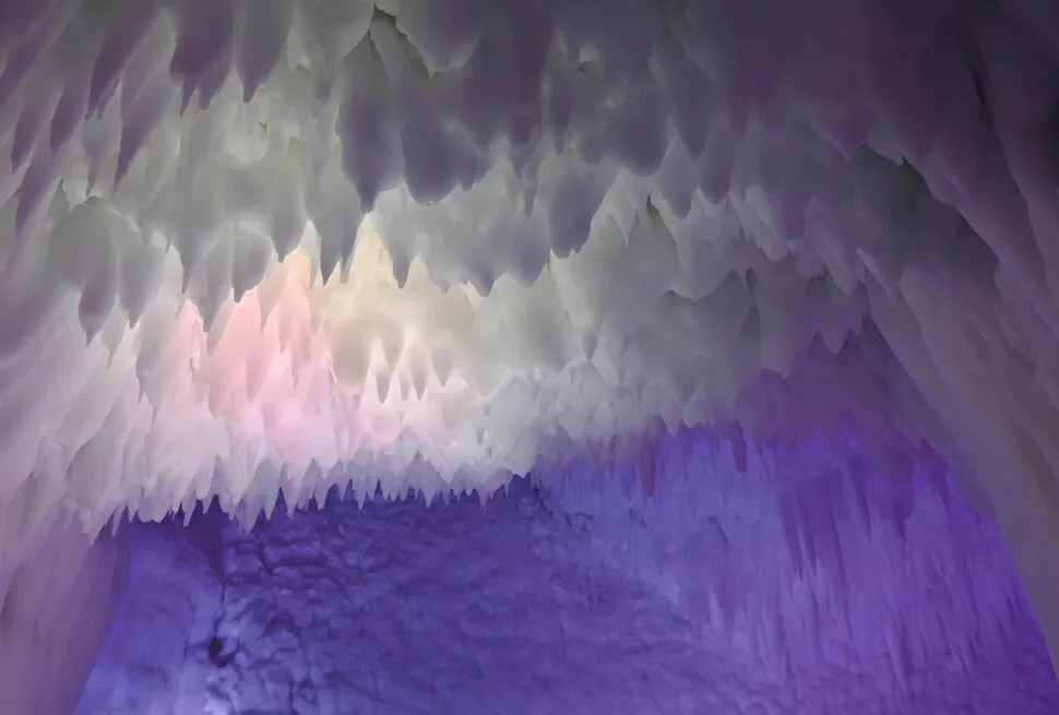 Ice cave ceiling with hanging icicles bathed in purple and blue light, creating a cool, otherworldly glow on the icy walls,Yunqiu Mountain Ice Caves,Linfen,Shanxi