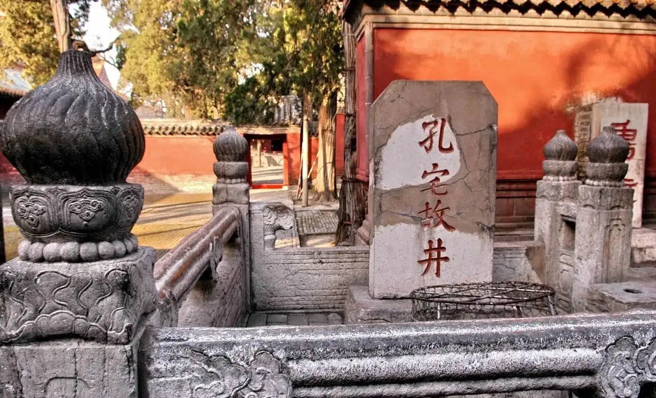 Ancient stone well and monument at a historic Chinese temple site in Beijing.