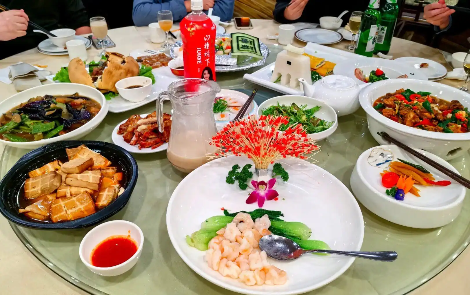 A colorful Chinese banquet with various traditional dishes on a round table.