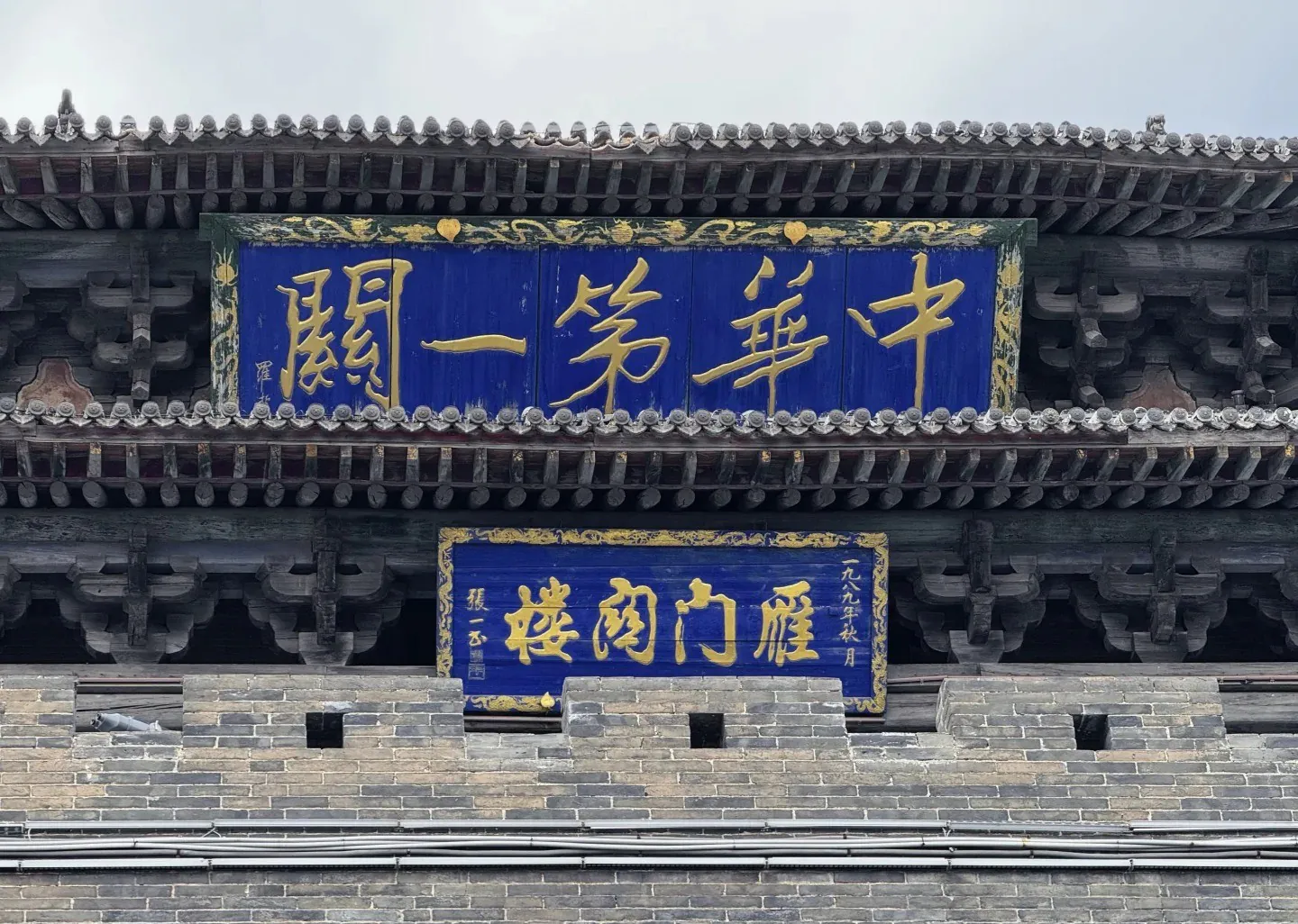 Traditional Chinese building entrance with blue and gold signboards displaying Chinese characters.