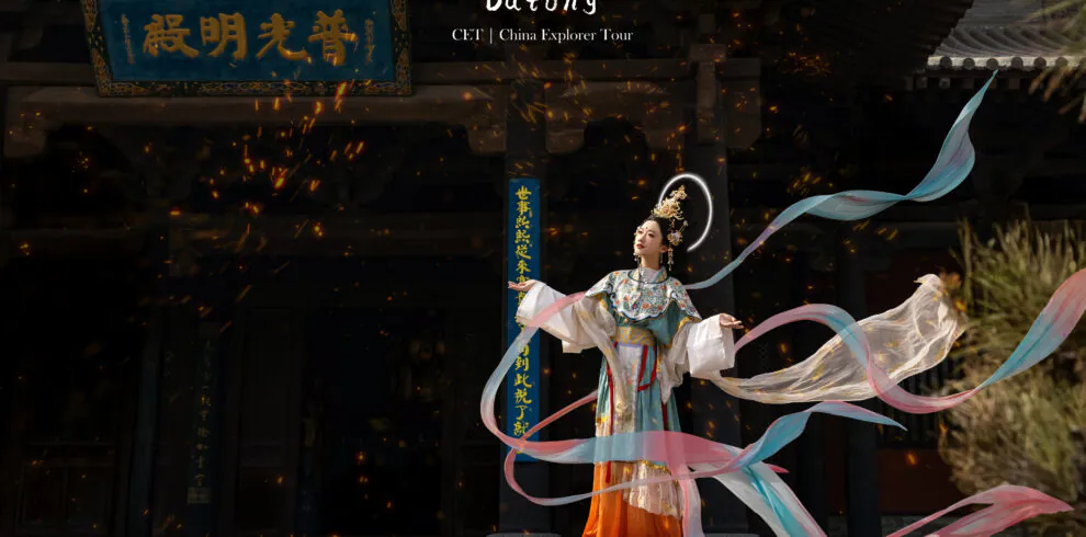 A dancer in traditional Chinese costume performs with flowing pastel ribbons in front of a dark temple entrance and burning embers in the air.Hanfu photo shooting,Datong,Shanxi
