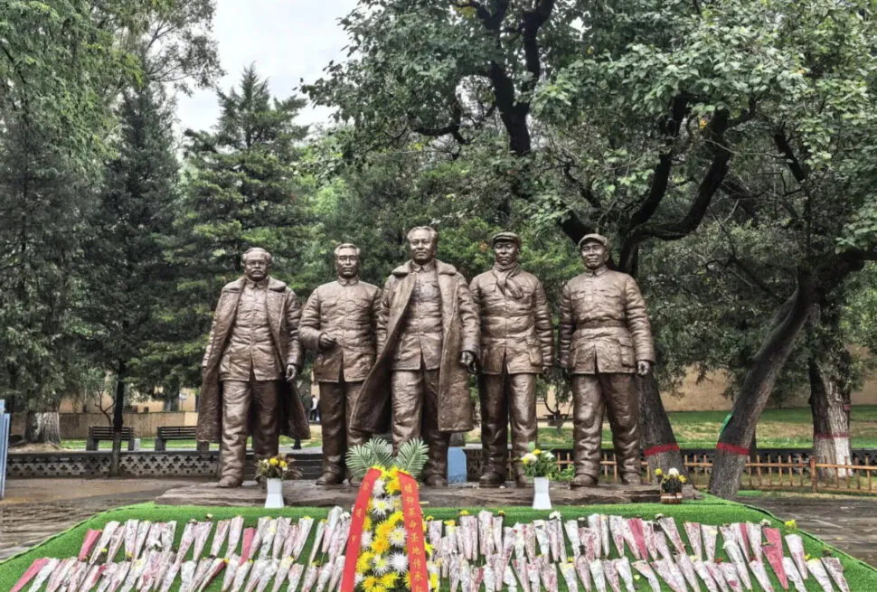 Zaoyuan Revolutionary Former Site ,Yan`an,Chinatrip Bronze statues of five soldiers standing in a park with trees and flowers in front.