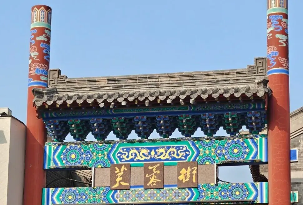 Traditional Chinese gate with colorful decorative patterns and Chinese characters.