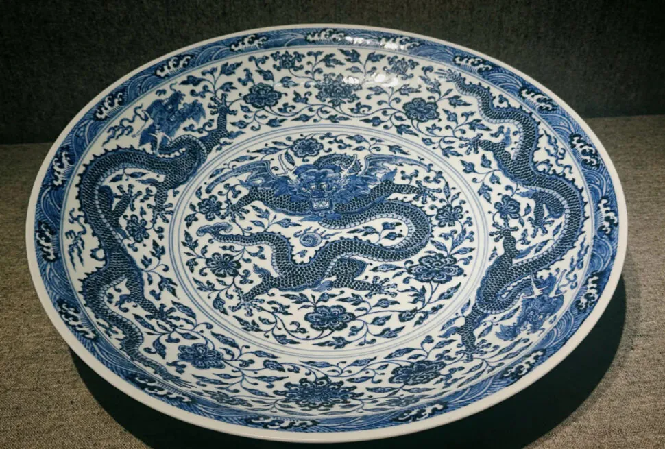 Blue and white porcelain plate with dragon motifs and floral patterns in circular design. (Decorative ceramic plate.)