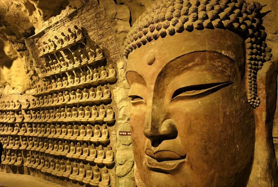 Thousand Buddha Mountain,Jinan,Chinatour Large Buddha head and numerous smaller Buddha statues in a cave temple.