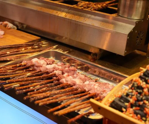 Xi'an Muslim Quarter and Great Mosque,Xi`an,Chinatour Skewers of raw meat arranged on a metal tray at a street food stall with a grill in the background