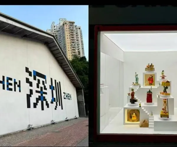 Exterior wall of the Shenzhen art installation with bold stylized characters; next to a lit white display case containing tiered miniature sculptures.