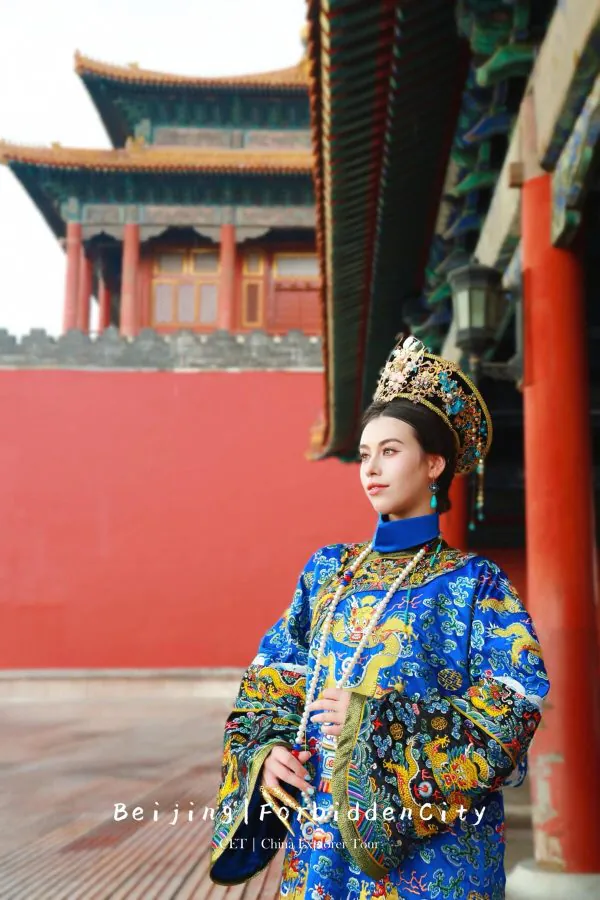 hanfu photoshoot, the forbidden city, beijing, qing dynasty, female, solo, chinatravel, Portrait of a woman in an ornate blue dragon-embroidered robe and gold crown, standing in a red-walled courtyard of the Forbidden City in Beijing.