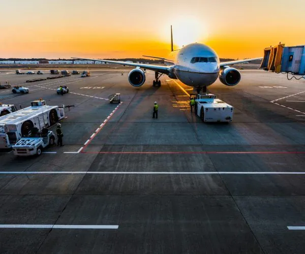 airport, Chengdu, Chinatravel, Airplane at gate during sunset with ground crew and luggage carts on tarmac.