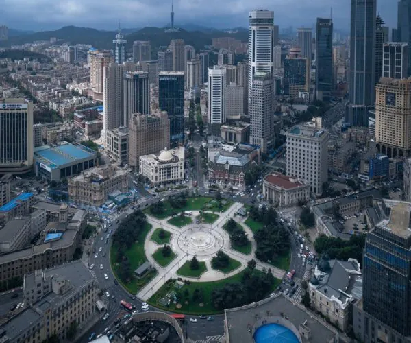 Zhongshan Square,Dalian,China tour Aerial view of a downtown city with a large circular plaza green space at center and tall skyscrapers around.
