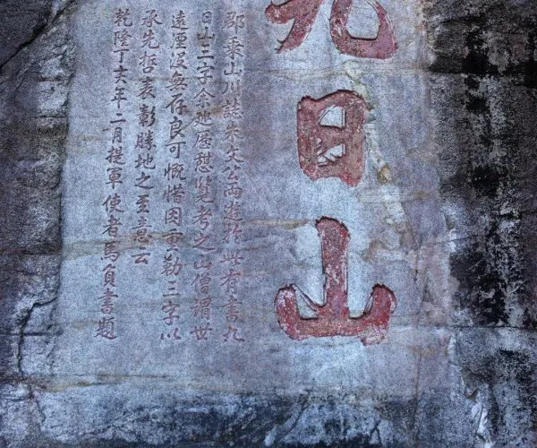 Jiuri Mountain Wind-praying Stone Inscription,Quanzhou,Chinatravel Stone rock slab with Chinese inscription: large red characters on the right and a column of smaller characters on the left of the slab.