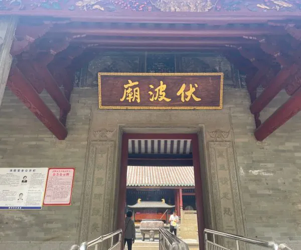 Fubo Hill Temple,Guilin,Chinatravel Entrance to a traditional Chinese temple with a gold Chinese-character plaque above the doorway, carved stone pillars, and red wooden beams.