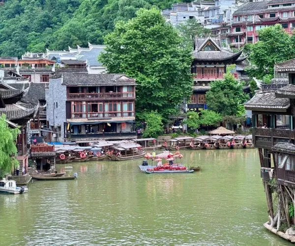 Fenghuang,Hunan,Chinatour Traditional Chinese riverside village with wooden houses and lush green mountains.