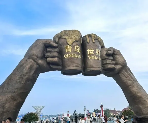 Qingdao International Beer City,Qingdao,Chinatravel Giant stone hands grip a central block with gold letters reading 'QINGDAO WORLD'.
