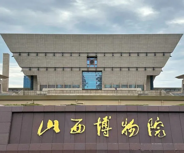 Shanxi Museum,Taiyuan,Chinatravel Front view of the Shanxi Museum exterior with a dark wall displaying large gold Chinese characters 山西博物院 against a cloudy sky.