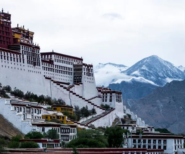 Potala Palace,Lhasa,Chinatravel Potala Palace perched on a hillside with white walls and red accents against snow-capped mountains.