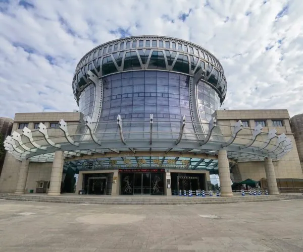 Guangxi Museum of Nationalities,Nanning,Chinatravel Front view of a futuristic circular glass museum with a curved skylight and metal supports over the entrance.