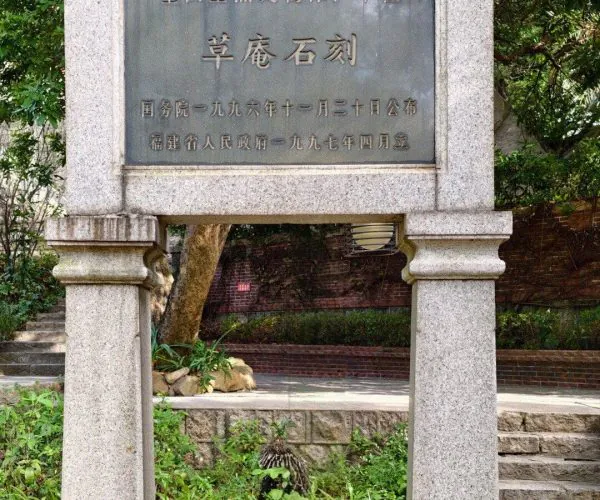Grass Hut Manichaeism Site,Quanzhou,Chinatravel Stone sign with a Chinese inscription framed by two granite pillars in a garden.
