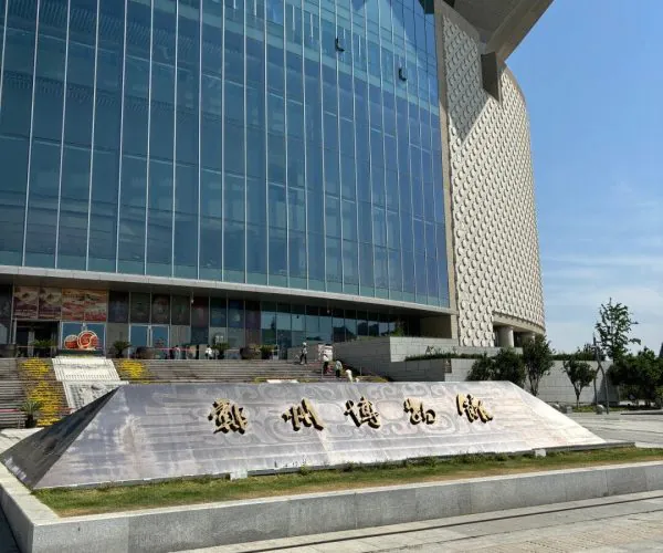 Zhengzhou Museum,Zhengzhou,Chinatravel Modern glass-front building with a decorative ramp and gold Chinese characters in front.
