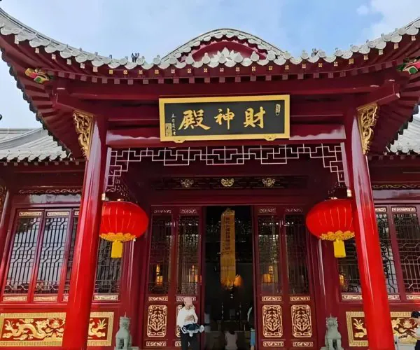 Changchun Guan Taoist Temple,Wuhan,Chinatravel Front view of a traditional red Chinese temple entrance with gold detailing and two red lanterns hanging beside the doors.