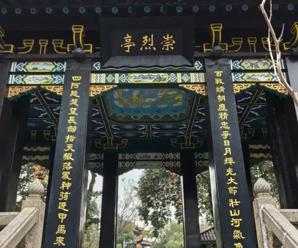 Tianxin Pavilion Historic Area,Changsha,Chinatravel Ornate Chinese temple gate with gold inscriptions, black pillars, and a tiled roof leading to a courtyard with visitors.