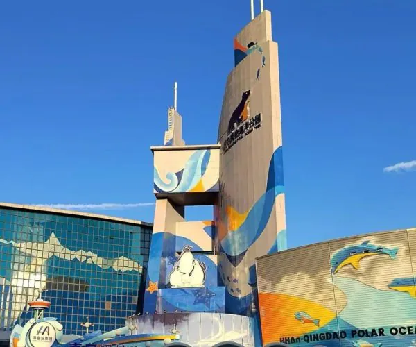 Qingdao Polar Ocean World,Qingdao,Chinatravel Entrance to a colorful marine park building with tall mural towers, ocean-wave artwork, and a sign that reads Qingdao Polar Ocean World.