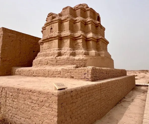 Gaochang Ruins,Turpan,China tour Ancient stepped brick monument in a sandy desert, surrounded by low brick walls on a raised platform